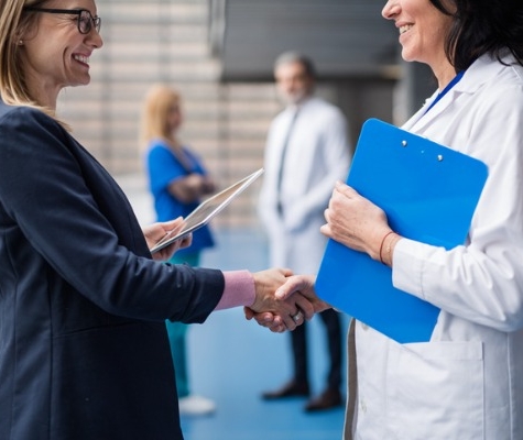 Image of business person and doctor shaking hands