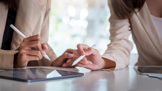 Image of two people discussing over a tablet